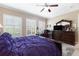 Bedroom featuring dark wood furnishings, plantation shutters, and office space at 18258 Wayne Rd, Odessa, FL 33556