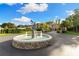 Grand home featuring a beautiful fountain in the front yard with lush landscaping, enhancing its curb appeal under blue skies at 18258 Wayne Rd, Odessa, FL 33556