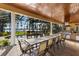 Covered outdoor dining area with lake views, a grill, and easy access to the pool at 18258 Wayne Rd, Odessa, FL 33556