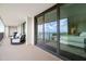 A condo balcony featuring an outdoor seating area and floor-to-ceiling glass doors to the interior at 100 Oakmont Ln # 802, Belleair, FL 33756
