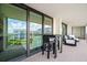 This condo balcony features a glass door leading to living area, with a table and chair set at 100 Oakmont Ln # 802, Belleair, FL 33756