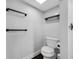 Clean bathroom featuring a toilet, glass-walled shower and black hardware, and hardwood floors at 100 Oakmont Ln # 802, Belleair, FL 33756
