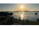 Beautiful sunrise over the bay, with the community swimming pool and palm trees in the foreground at 100 Oakmont Ln # 802, Belleair, FL 33756