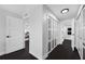 Bright hallway with dark floors, white doors, and glass paneled closets at 100 Oakmont Ln # 802, Belleair, FL 33756