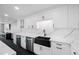 Bright kitchen featuring quartz countertops, black farmhouse sink, wine cooler, and stainless steel dishwasher at 100 Oakmont Ln # 802, Belleair, FL 33756