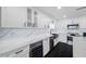 An updated kitchen featuring white cabinets and quartz countertops and stainless steel appliances at 100 Oakmont Ln # 802, Belleair, FL 33756