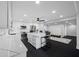 Modern kitchen with white cabinets, quartz countertops, stainless appliances and a large island at 100 Oakmont Ln # 802, Belleair, FL 33756