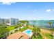 A beautiful view of the community pool with palm trees and the bay in the background at 100 Oakmont Ln # 802, Belleair, FL 33756