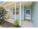 Inviting front porch with blue siding and white columns, offering a cozy entrance to the home at 105 1St Se Ave, Lutz, FL 33549