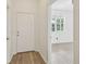 Hallway featuring light, modern flooring and white doors, with a glimpse of a windowed room at 105 1St Se Ave, Lutz, FL 33549
