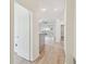 Hallway leading to kitchen, dining, and living spaces with light modern flooring and white trim at 105 1St Se Ave, Lutz, FL 33549