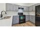 Modern kitchen featuring gray cabinets, sleek black appliances, and durable countertops at 105 1St Se Ave, Lutz, FL 33549
