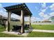 Spacious backyard features a patio with a pergola, outdoor seating, and a lush green lawn at 10826 Trailing Vine Dr, Tampa, FL 33610