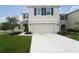 Inviting two-story home featuring a spacious driveway and attached two-car garage at 10826 Trailing Vine Dr, Tampa, FL 33610