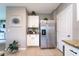 Bright kitchen features stainless steel refrigerator, white cabinets, tan tile flooring, and attractive granite counters at 10826 Trailing Vine Dr, Tampa, FL 33610