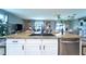 Granite kitchen island with seating for three with view of living room and dining area beyond at 10826 Trailing Vine Dr, Tampa, FL 33610