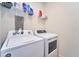 A laundry room featuring a washer and dryer, along with shelving for storage at 10826 Trailing Vine Dr, Tampa, FL 33610