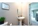 Cozy powder room with a pedestal sink, tasteful wall art, and compact design at 10826 Trailing Vine Dr, Tampa, FL 33610