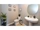 Chic powder room featuring modern fixtures, stylish decor, and a pedestal sink at 10826 Trailing Vine Dr, Tampa, FL 33610
