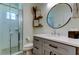 Modern bathroom with a glass-enclosed shower, grey vanity, and stylish decor at 11606 Quiet Forest Dr, Tampa, FL 33635
