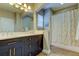Bathroom featuring double sinks, dark cabinetry with gold hardware, and shower with decorative curtain at 11606 Quiet Forest Dr, Tampa, FL 33635