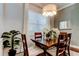 Dining area featuring a dark wood table set with chairs, a large window, and modern lighting at 11606 Quiet Forest Dr, Tampa, FL 33635