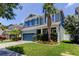 Two-story home with blue accents, attached garage, and well-maintained lawn at 11606 Quiet Forest Dr, Tampa, FL 33635