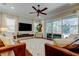 Open-concept living room with a large rug, ceiling fan, and access to the pool at 11606 Quiet Forest Dr, Tampa, FL 33635