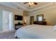 Bright main bedroom with tray ceiling, TV, private bathroom, large windows, and soft carpet at 11606 Quiet Forest Dr, Tampa, FL 33635