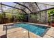 Inviting screened pool with lush landscaping, travertine decking and ample space at 11606 Quiet Forest Dr, Tampa, FL 33635