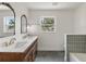 Bathroom featuring double sinks, vanity, and bathtub with tiled wall at 11764 Pinedale Ave, Seminole, FL 33772