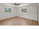 Bedroom featuring hardwood floors and plenty of natural light from two windows at 11764 Pinedale Ave, Seminole, FL 33772