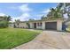 Front exterior with driveway and garage showcasing landscaping and the home's facade at 11764 Pinedale Ave, Seminole, FL 33772