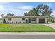 Charming single-story home boasts a well-manicured lawn, attached garage, and neutral exterior at 11764 Pinedale Ave, Seminole, FL 33772
