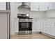 A modern kitchen featuring sleek stainless steel appliances, white cabinets and countertops, and updated hardware at 11764 Pinedale Ave, Seminole, FL 33772