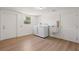 A laundry room with new washer, dryer, sink and light wood-look flooring at 11764 Pinedale Ave, Seminole, FL 33772