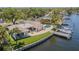 Waterfront property featuring a backyard pool, boat dock, well-maintained lawn, and a patio area at 1185 36Th Ne Ave, St Petersburg, FL 33704