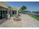 Waterfront backyard with stone patio, fire pit, stainless steel appliances, and dock access at 1185 36Th Ne Ave, St Petersburg, FL 33704