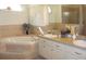 Bright bathroom featuring a soaking tub, double vanity sinks, and tiled walls at 12271 Centralia Rd, Weeki Wachee, FL 34614