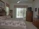 Comfortable bedroom with a ceiling fan, sliding glass doors, and warm lighting at 12271 Centralia Rd, Weeki Wachee, FL 34614
