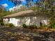 Angle view of the property's exterior, showcasing a glimpse of the driveway and simple landscaping at 12271 Centralia Rd, Weeki Wachee, FL 34614