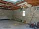 Inside the garage with visible ceiling beams, concrete walls, and a small window for natural light at 12271 Centralia Rd, Weeki Wachee, FL 34614