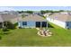 Aerial view of the backyard features a screened-in porch and a stone seating area with Adirondack chairs at 12517 Nantahala Run, Parrish, FL 34219
