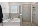 Modern bathroom featuring a combined bathtub and shower with gray tiling and glass door at 12517 Nantahala Run, Parrish, FL 34219