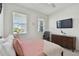 Bright bedroom with two windows, a TV, dresser, and modern decor at 12517 Nantahala Run, Parrish, FL 34219