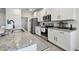 Modern kitchen featuring stainless steel appliances, granite countertops, white cabinets, and a convenient layout at 12517 Nantahala Run, Parrish, FL 34219