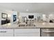 Close-up of kitchen island with granite countertops, sink, and stainless steel dishwasher overlooking the open-concept living room at 12517 Nantahala Run, Parrish, FL 34219