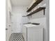 Functional laundry room featuring modern washer and dryer, stylish wallpaper, and open shelving for storage at 12517 Nantahala Run, Parrish, FL 34219