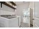 Well-organized laundry area with modern appliances, decorative wallpaper, and shelves for laundry essentials at 12517 Nantahala Run, Parrish, FL 34219