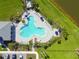 Aerial view of a neighborhood pool complete with lounge chairs, umbrellas, and nearby covered area at 12517 Nantahala Run, Parrish, FL 34219